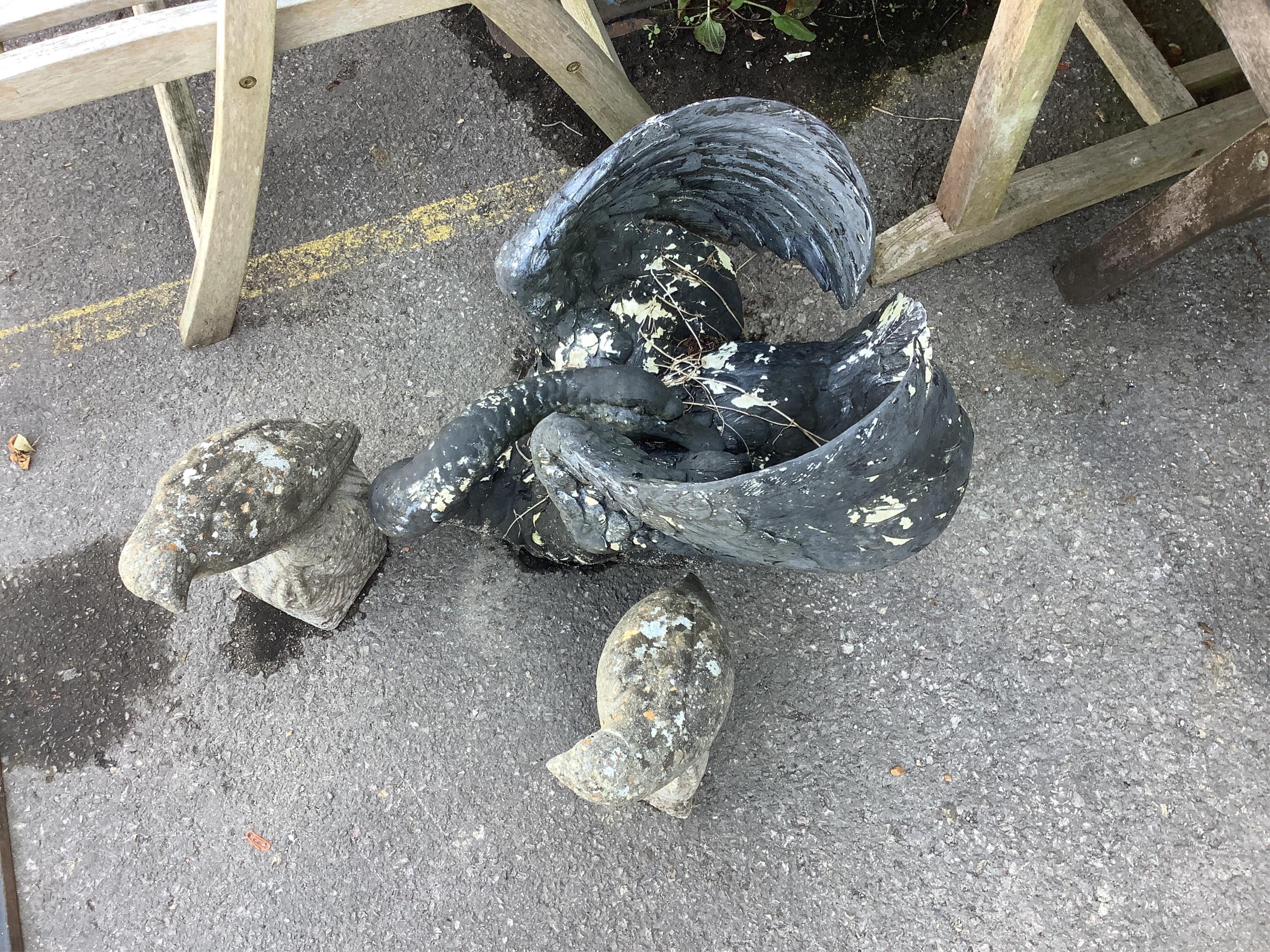 A painted resin swan garden ornament, length 54cm, together with a pair of reconstituted parrot garden ornaments. Condition - fair